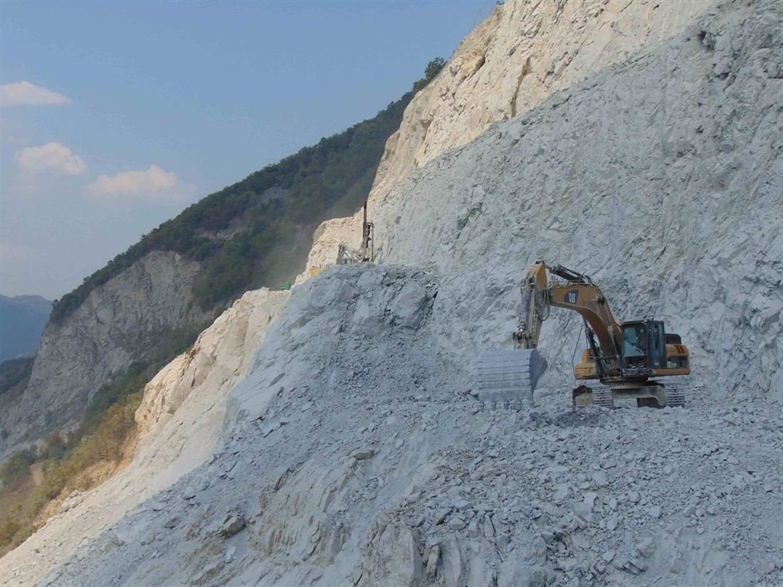 Bager i bušačka garnitura na etaži kamenoloma